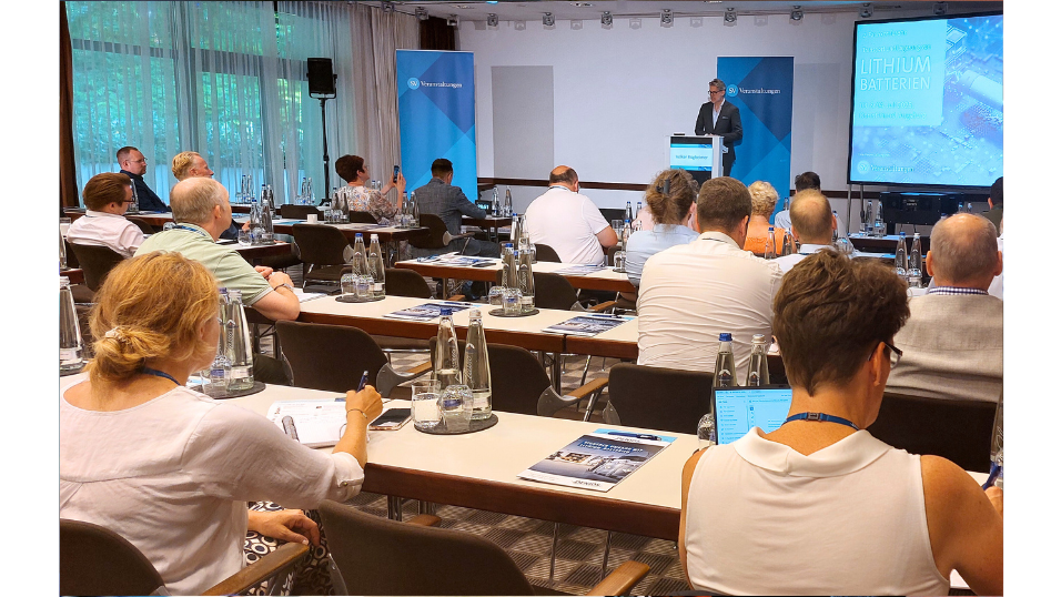 2. Fachkonferenz "Transport und Lagerung von Lithiumbatterien" - Volker Rügheimer steht auf der Bühne im Vortragsraum