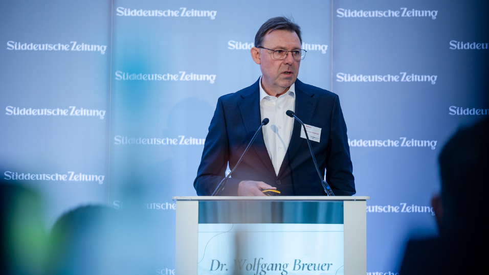 Dr. Wolfgang Breuer spricht am Rednerpult vor dem Bühnenhintergrund beim SZ-Versicherungstag 2026