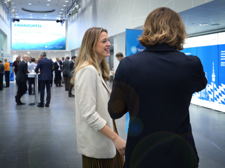 Zwei Teilnehmerinnen unterhalten sich entspannt beim Bayerischen Finanzgipfel in toller Location in München