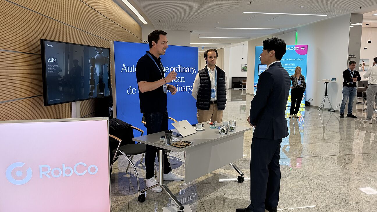 DIgitale Fabrik 2026 - Teilnehmer und Ausssteller unterhalten sich am RobCo Stand