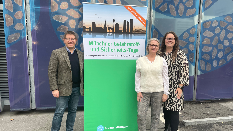 Das Team der 41. Münchner Gefahrstoff- und Sicherheitstage vor einem Banner der Veranstaltung